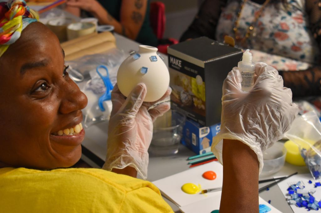 A Chaos Club participant holding up their personalized art project.