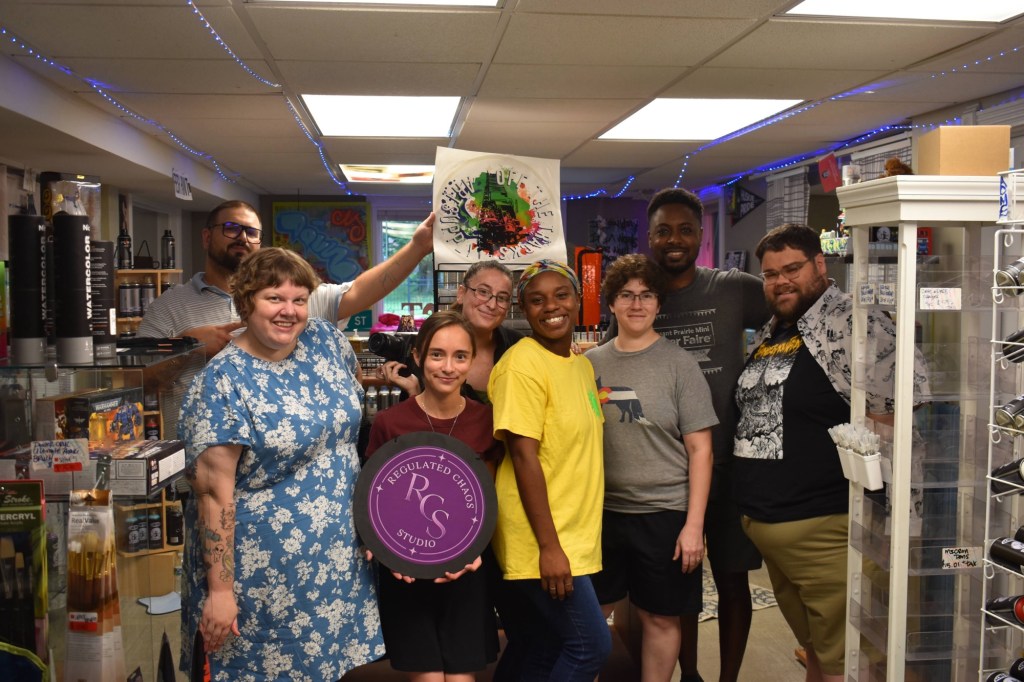 People crafting together Participants gathered at the first Regulated Chaos Studio, LLC Chaos Club in DeKalb, Illinois. This venue is in Off the Tracks Art Supply, LLC, inside the shop.